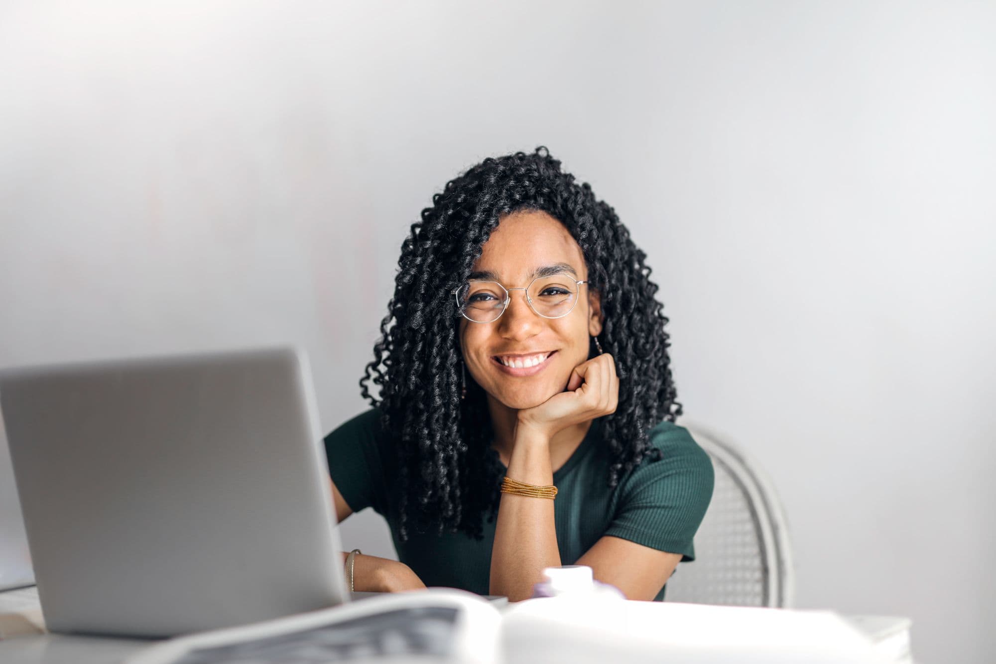 A creative professional at her laptop in a bright workspace