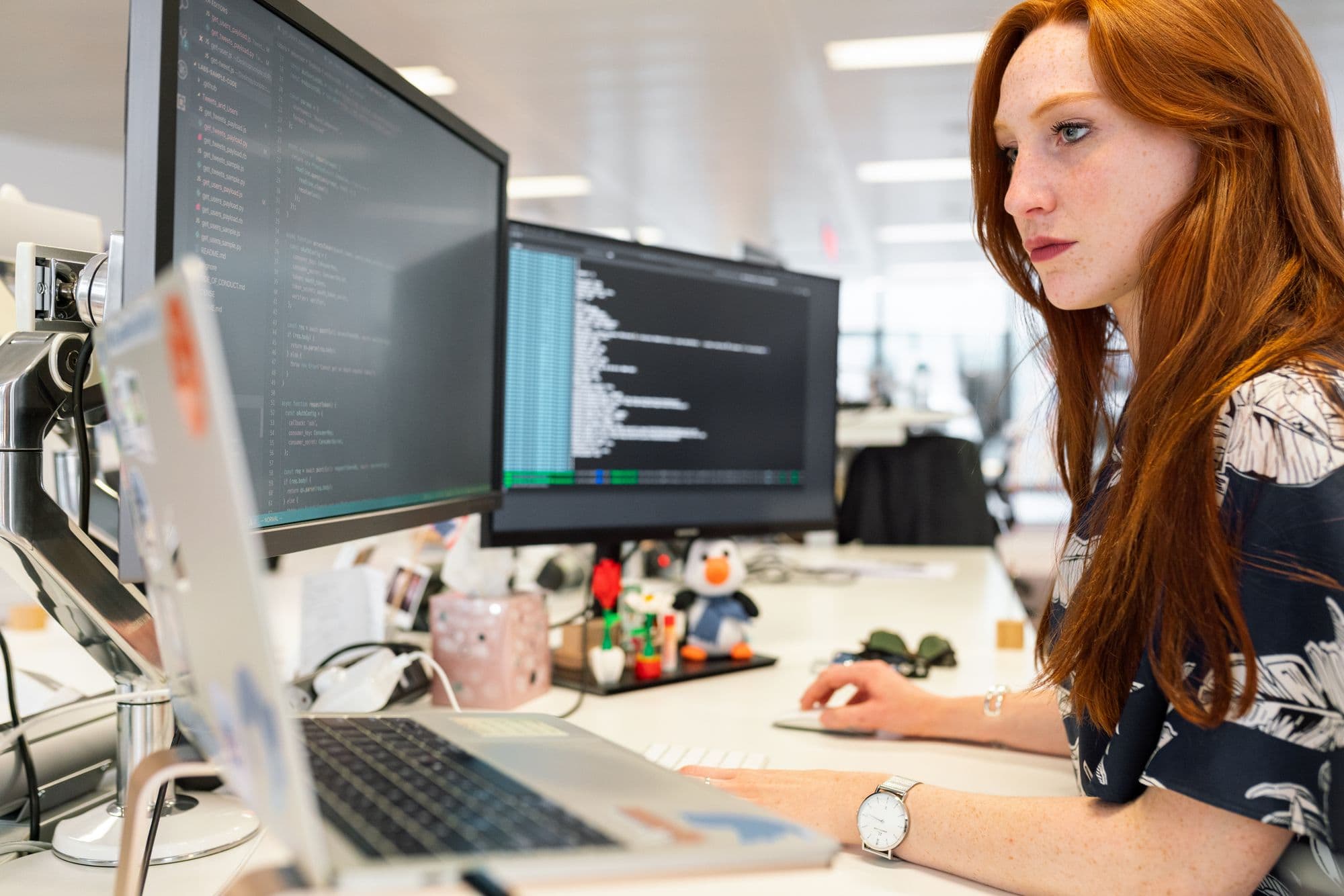 An engineer working at a desk with two monitors